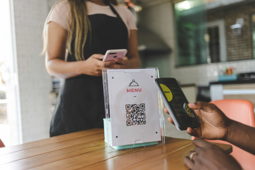 Businesswoman adapting to the changes in restaurant trends by implementing contactless ordering using a QR code.